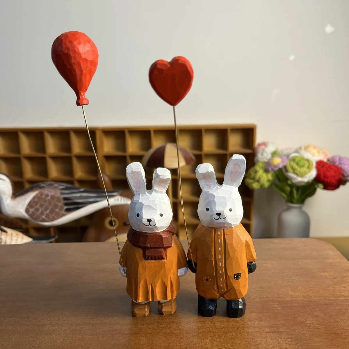 Pair of wooden bunny figurines holding heart and balloon accessories