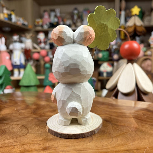 Hand-finished wooden bunny figurine holding a four-leaf clover on a wood base