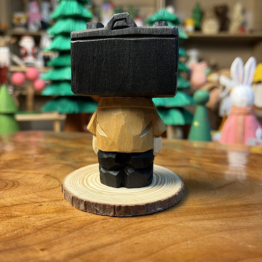 Hand-finished camera guy wooden figurine standing on a wooden studio desk