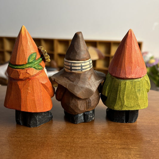 Forest gnome wooden figurine with leaf detail displayed on a warm wooden tabletop