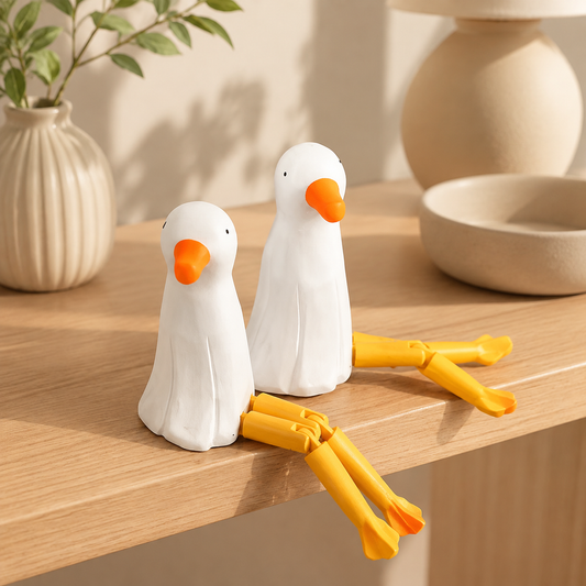 Long-leg seagull and mallard wooden bird figurines sitting on the edge of a shelf.