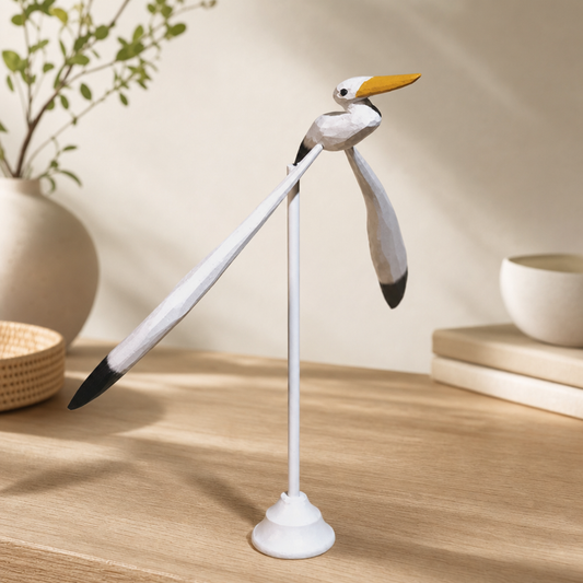 Hand-finished balancing seagull wooden figurine resting on a wooden tabletop display