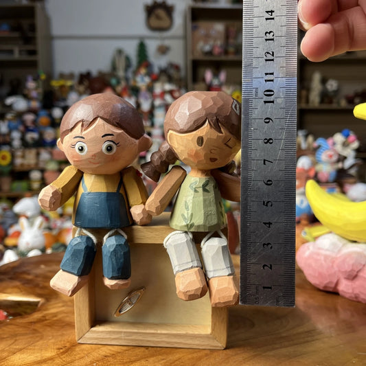 Hand-painted wooden couple figurine set featuring leg-dangling boy and girl