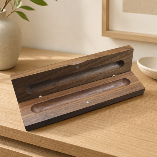 Black walnut double pen storage box open on a dark wood desk displaying two writing pens.