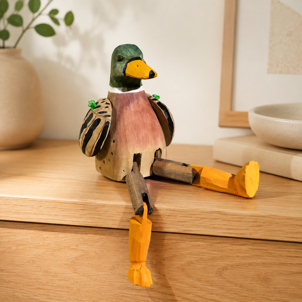 Long-leg duck wooden figurine perched on a wooden desk shelf.